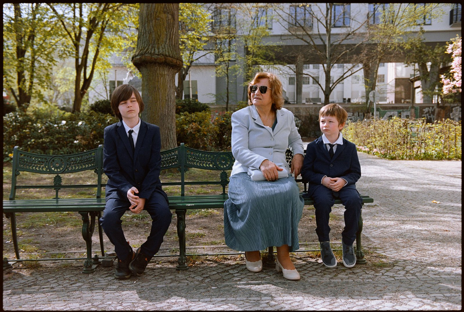 Guests on a park bench in the spring sun, Irena & Peter wedding in Berlin