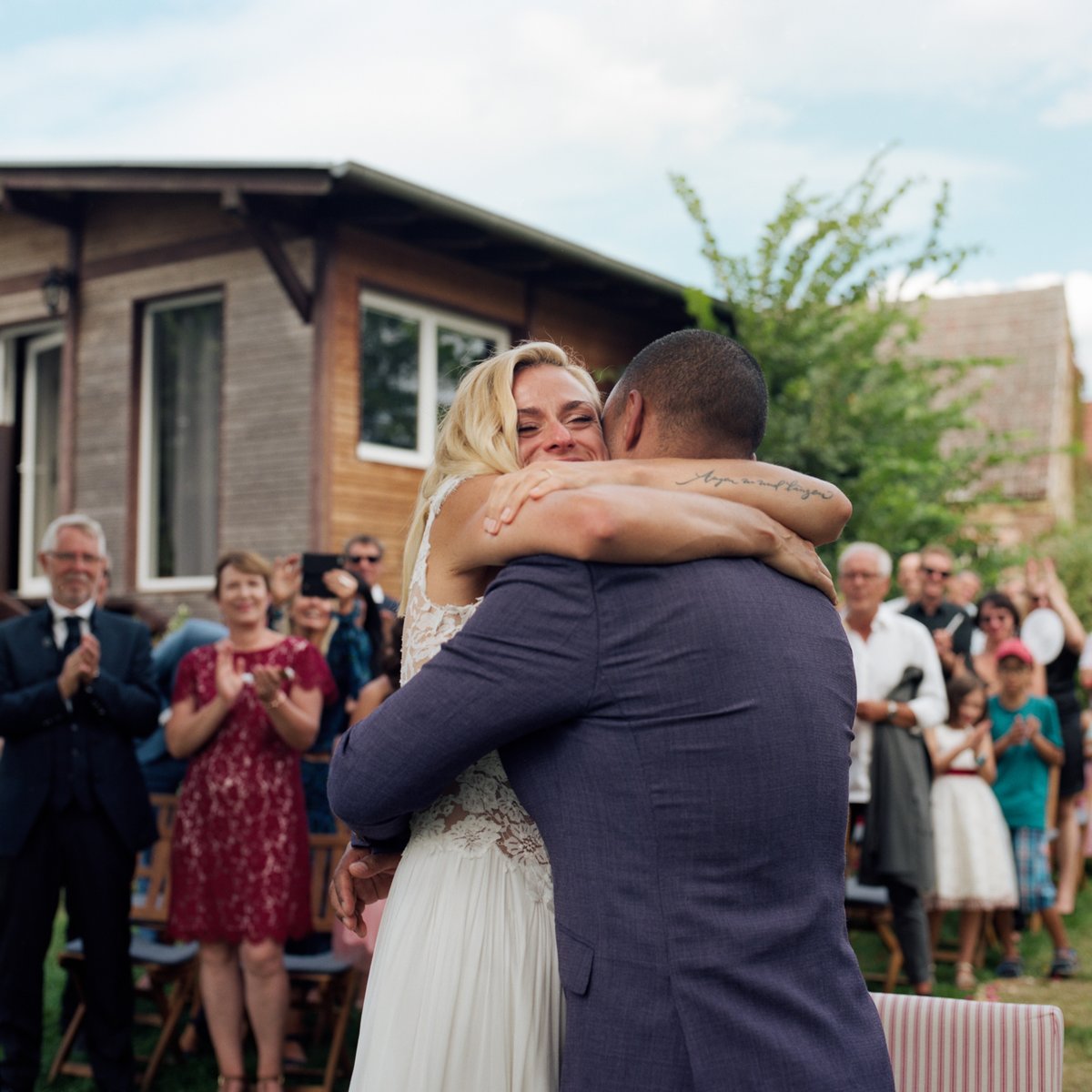 The couple embracing as their guests applaud