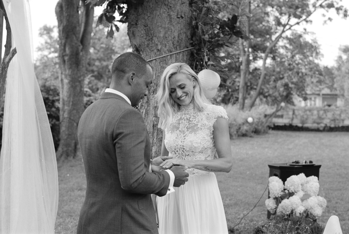 The couple exchanging rings in the garden, black and white