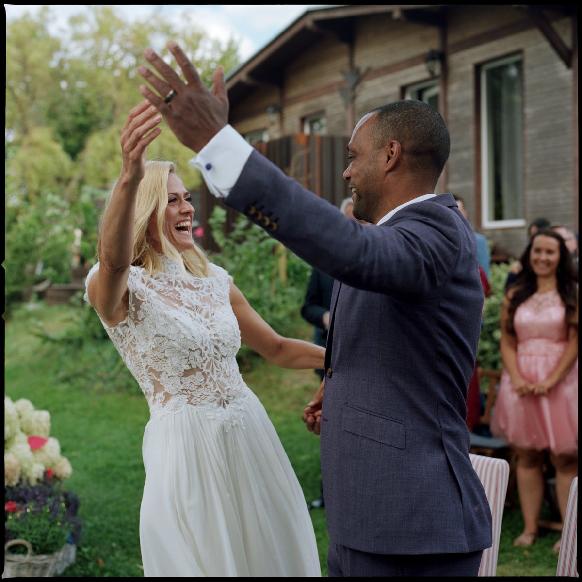 The couple laughing and raising their hands together