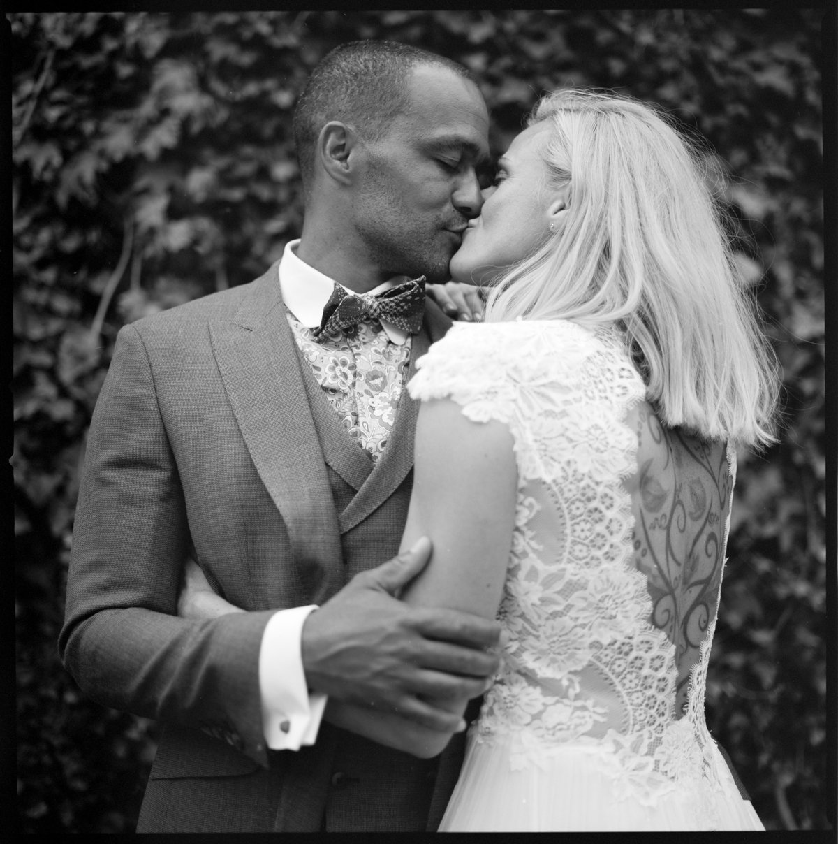 The couple in a close embrace among greenery, black and white