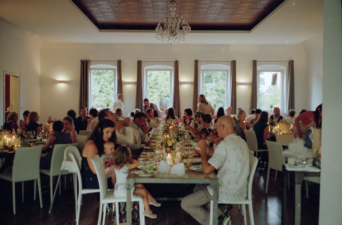 The reception hall set with long tables under a chandelier