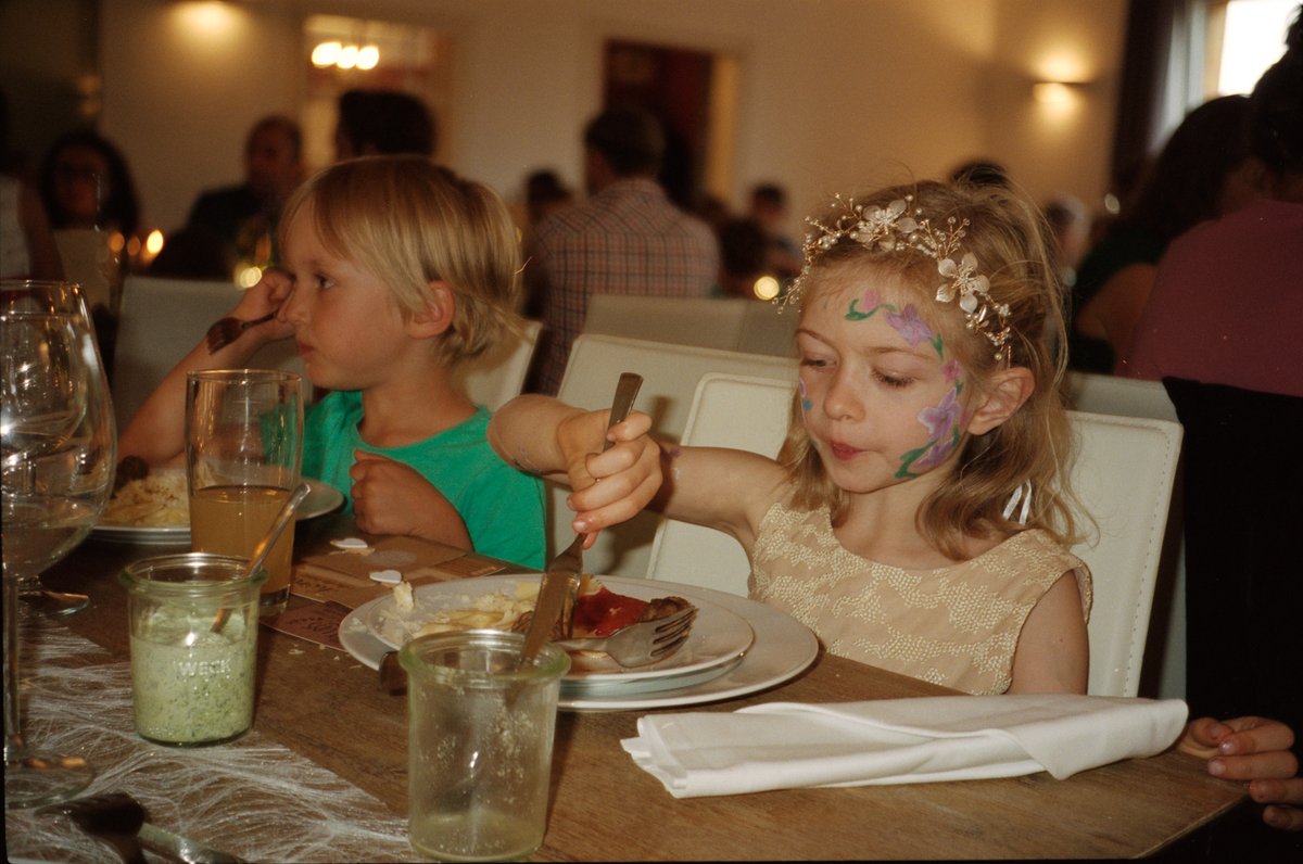 A young guest with painted face at the dinner table