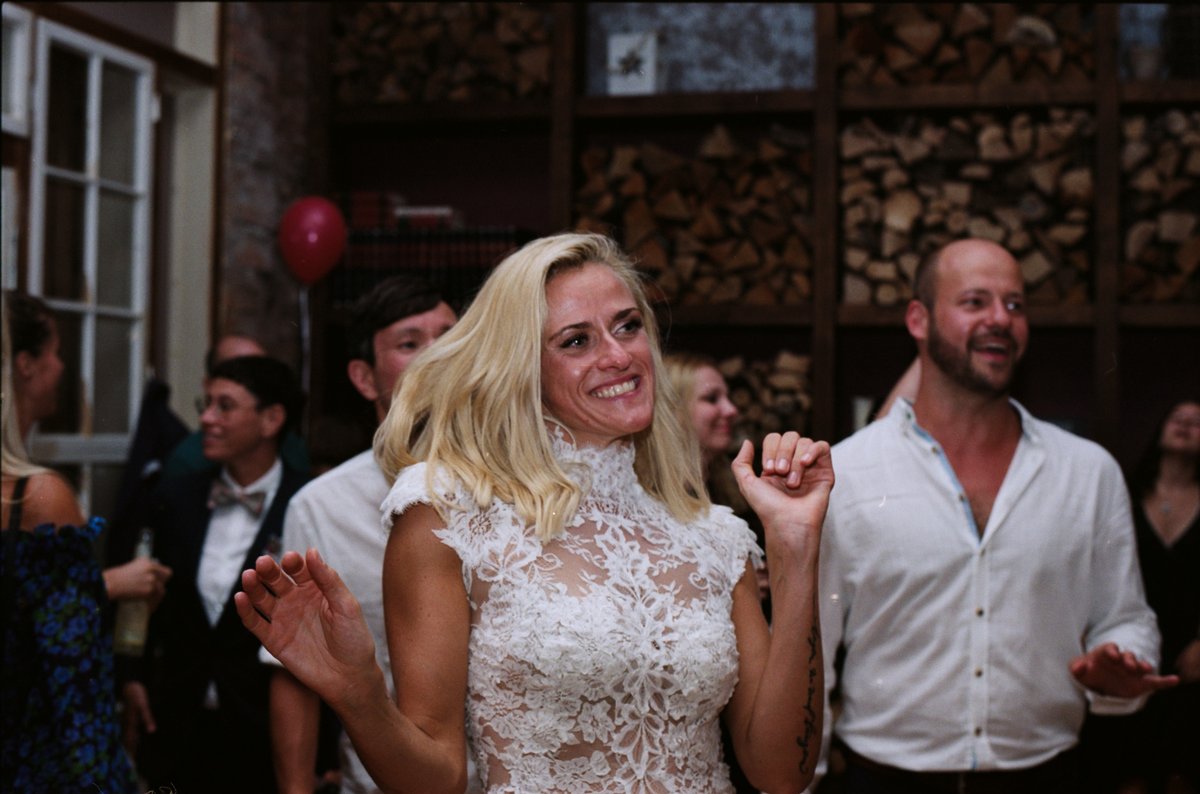 Guests dancing in a room lined with stacked firewood