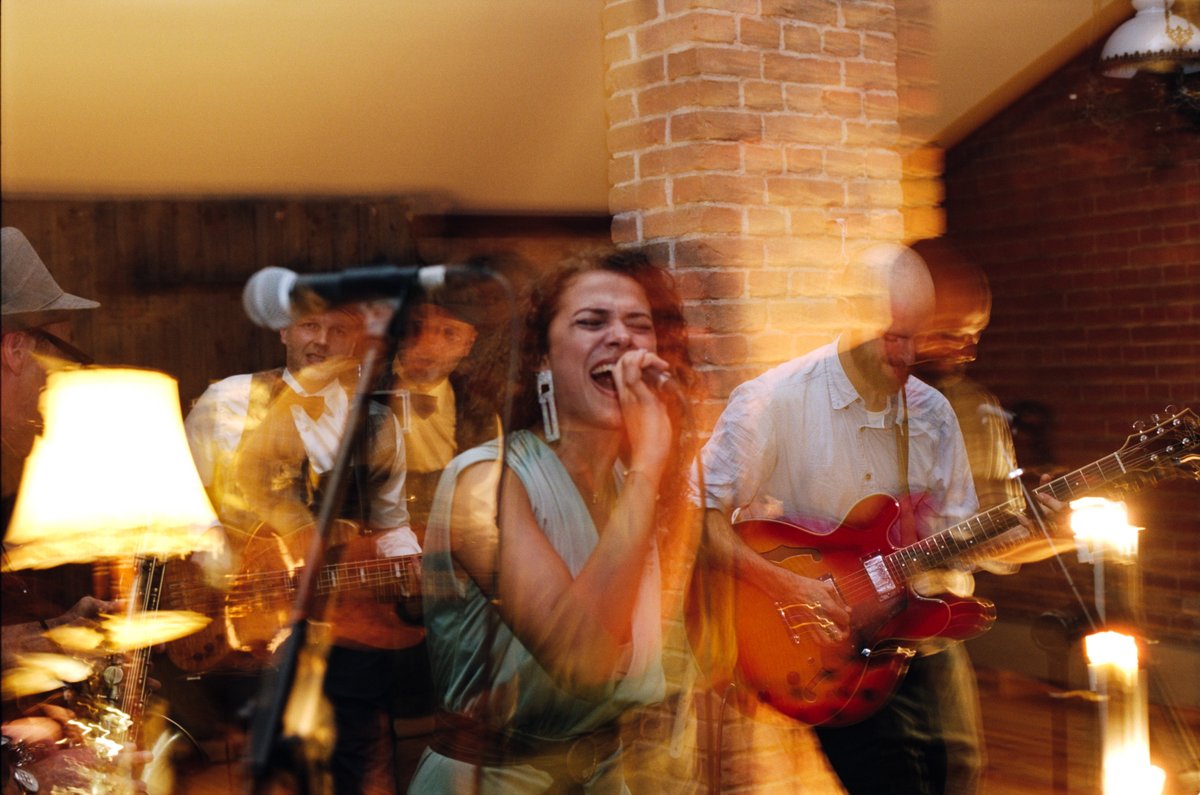 A singer and guitarist performing by candlelight