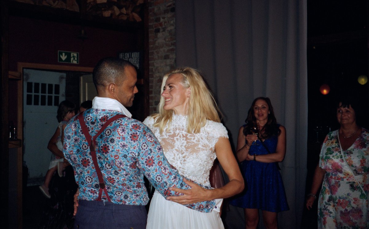 The bride dancing with a guest in a patterned shirt