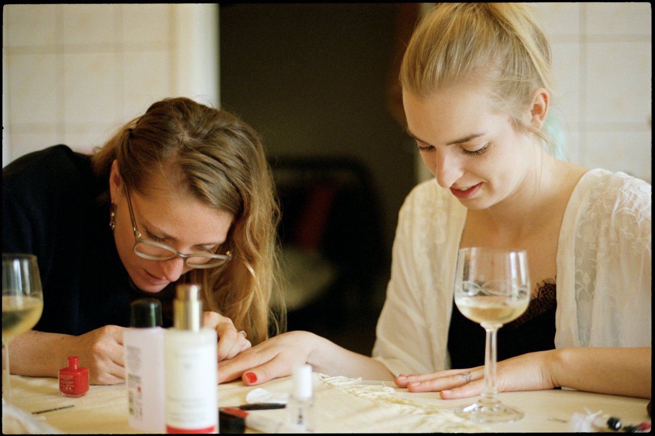 Die Braut und ein Gast machen sich gemeinsam am Tisch fertig