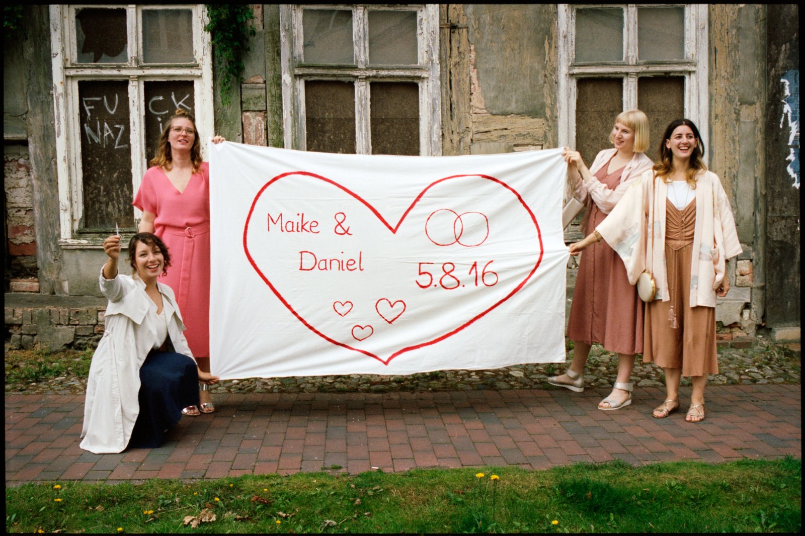 Gäste halten ein Banner für Maike und Daniel
