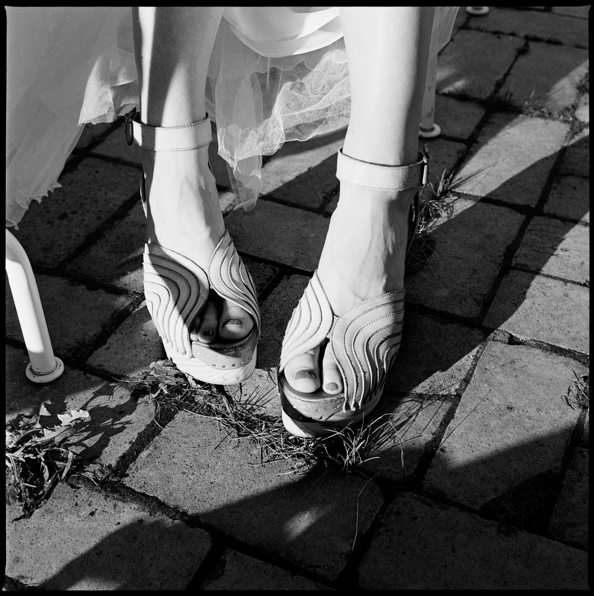 Die Schuhe der Braut auf Kopfsteinpflaster, in Schwarz-Weiß