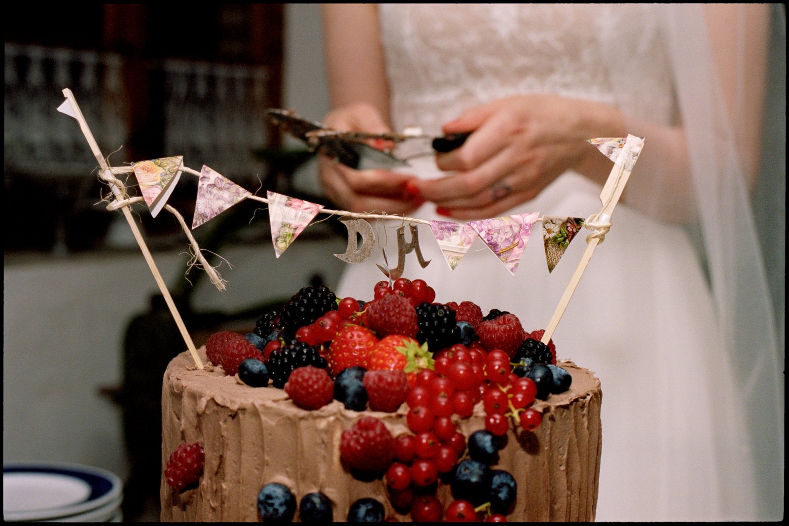 Die mit Beeren belegte Hochzeitstorte mit Papierwimpeln