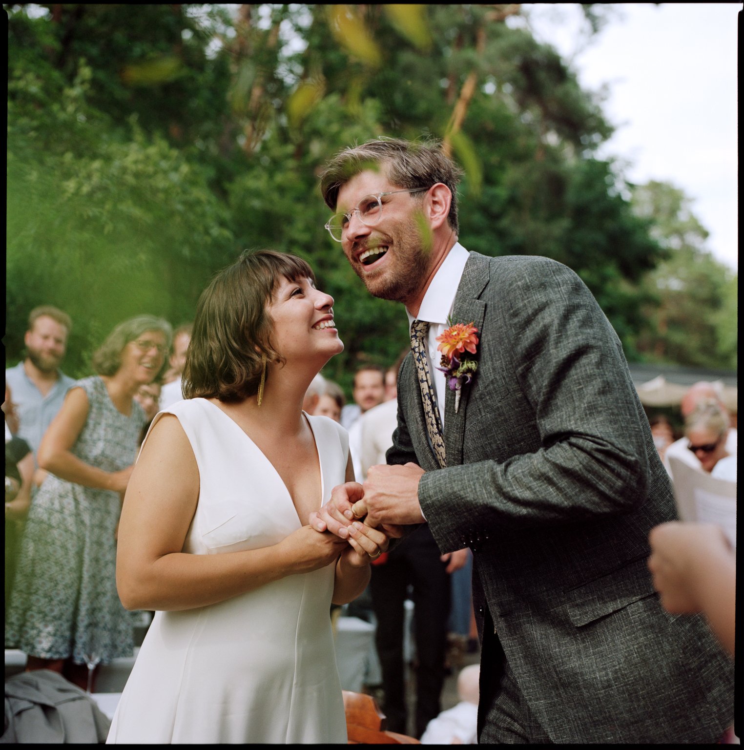 Das Paar lacht gemeinsam inmitten der Gäste, Hochzeit von Suelyn & Pascal in Groß Glienicke, Potsdam