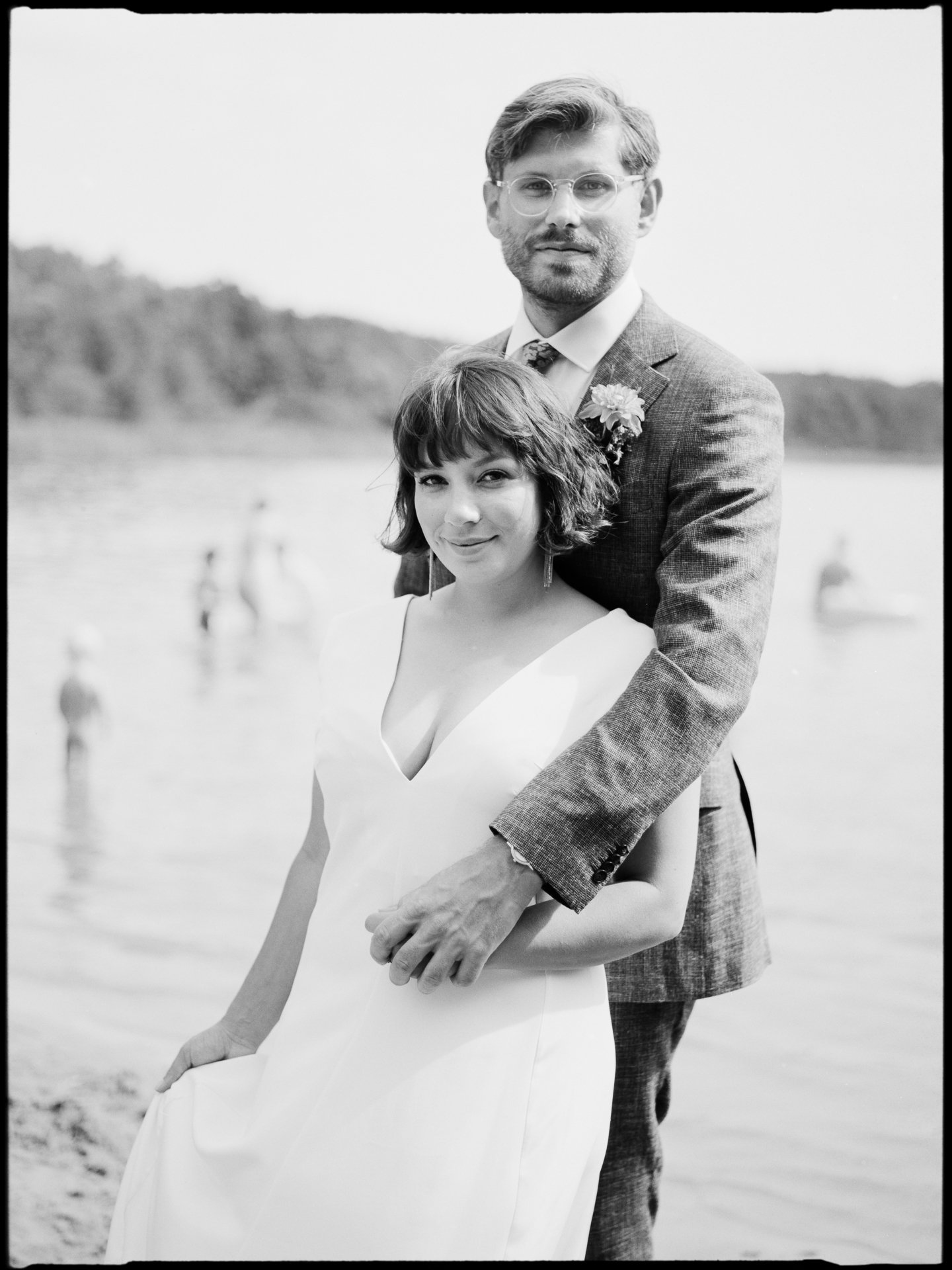 Portrait des Paares am See, Badende im Hintergrund, in Schwarz-Weiß