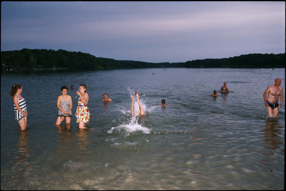 Gäste schwimmen im See in der Abenddämmerung