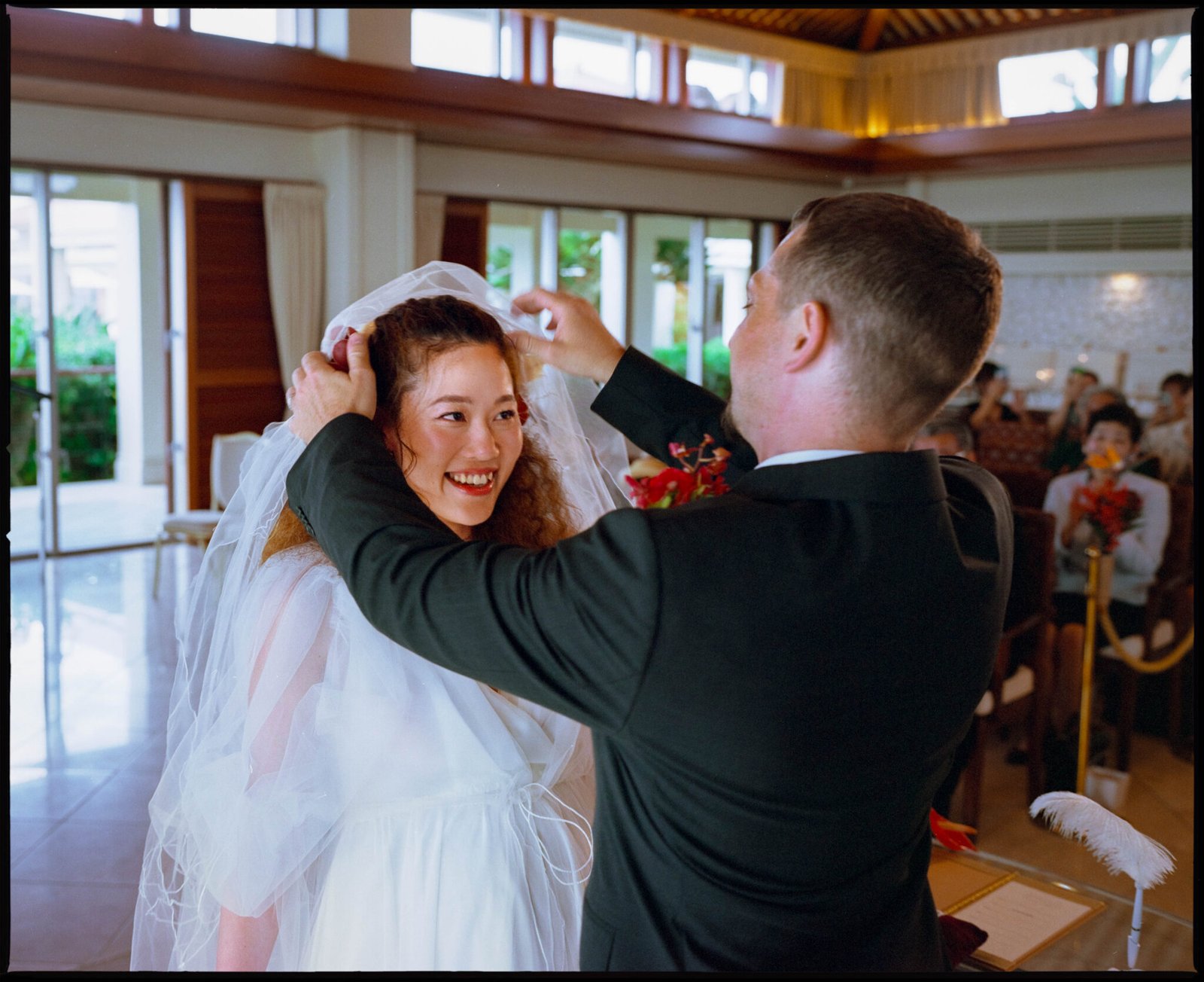 The groom lifting the bride's veil