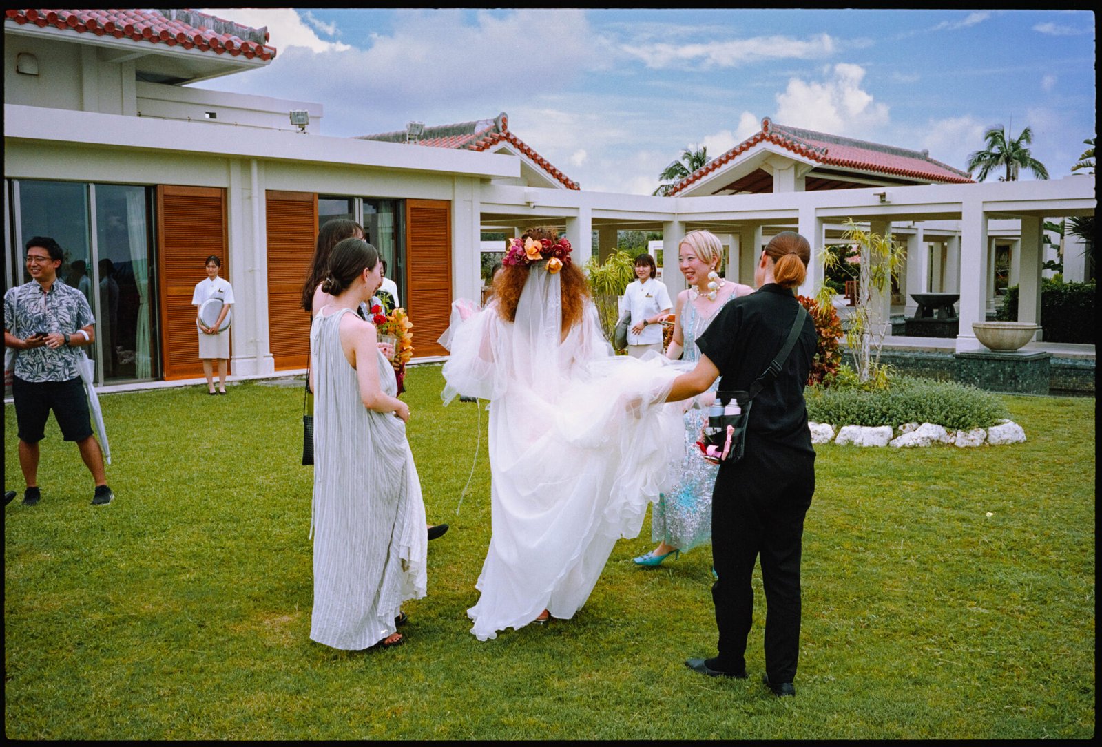 The couple on the lawn with guests, the sea behind