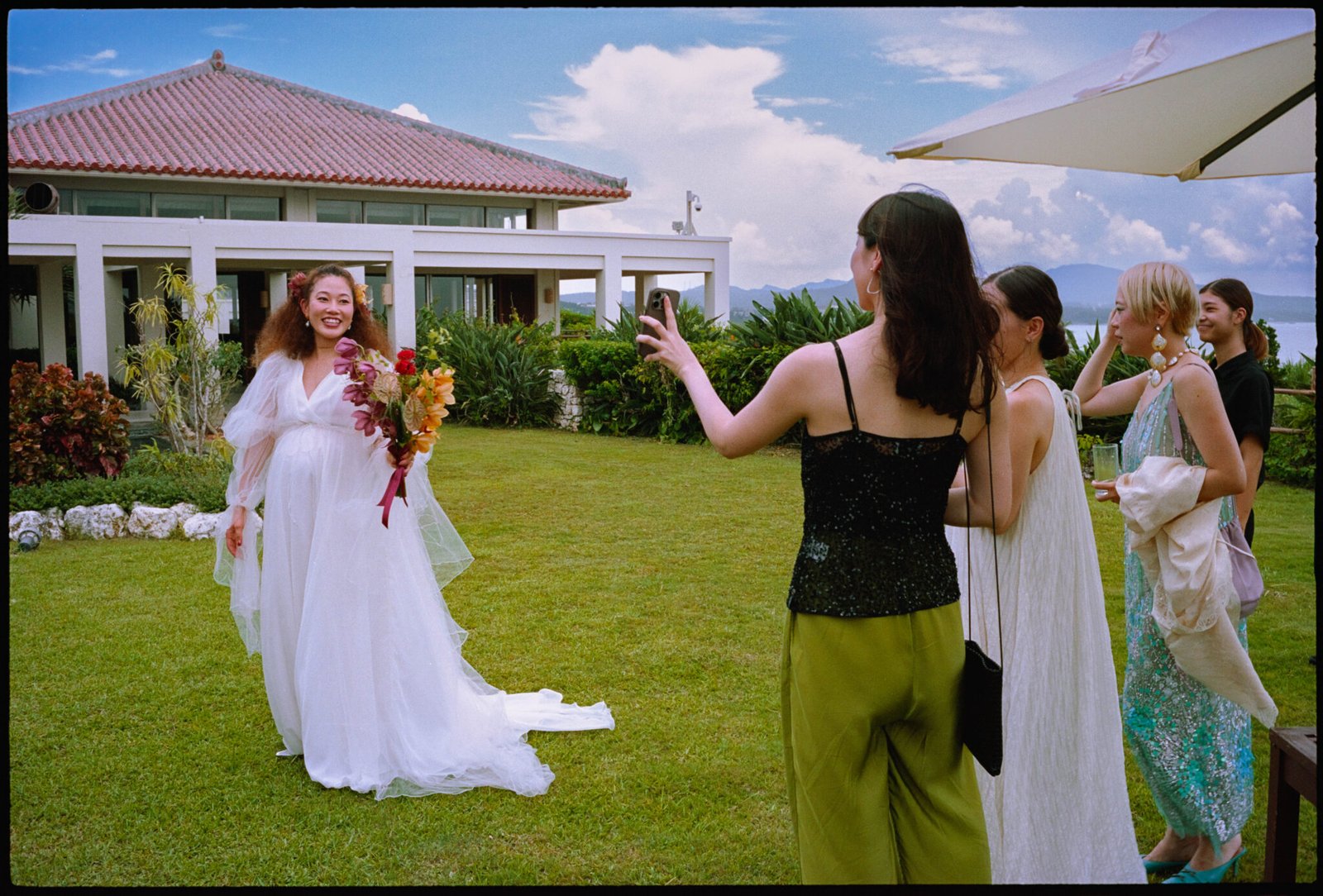 A guest photographing the bride on the lawn